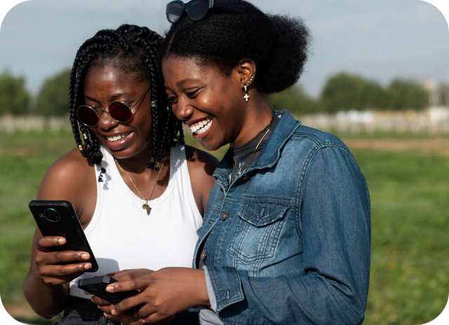 Two women using phone outdoors